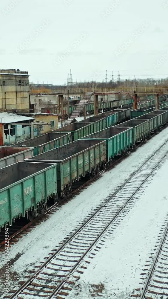 Four rows of containers are located at the railway station near the state building outside the city. Aerial view. Vertical video Four rows of containers are located at the railway station near the state building outside the city. Aerial view. Vertical video