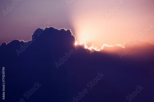 Every cloud has a silver lining. Sun rises over cumulus clouds its light rays breaking cover above the heavens