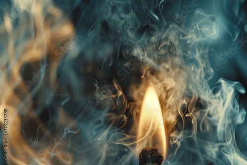 Lit matchstick with swirling smoke on a blurred background photo