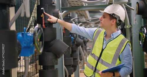 Εκτύπωση καμβά An industrial engineer in a hard hat and reflective vest inspecting machinery with clipboard paperwork in a manufacturing industrial facility