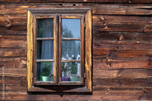 The old window of old wooden house. Background of wooden walls.