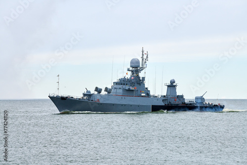 Russian warship armed with armament sails into sea toward military target to attack and destroy enemy  military ship performing strategic maneuver  Russian sea power deployment for tactical advantage