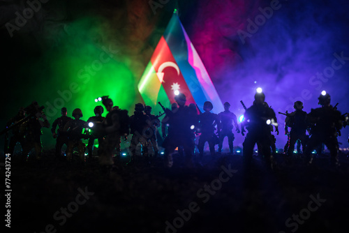 Azeri army concept. Silhouette of armed soldiers against Azerbaijani flag. Creative artwork decoration. Military silhouettes fighting scene dark toned foggy background. photo