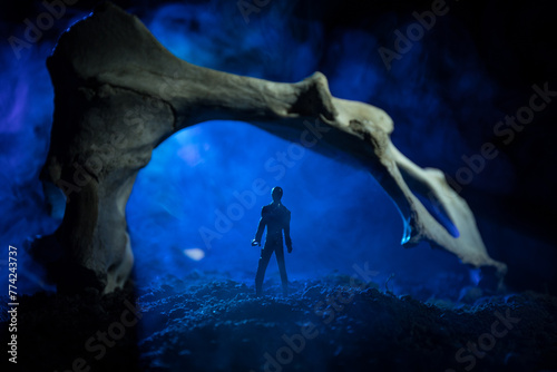 Artwork decoration with animal bone. Silhouette in an underground abandoned crypt. man standing in front of a cave entrance.