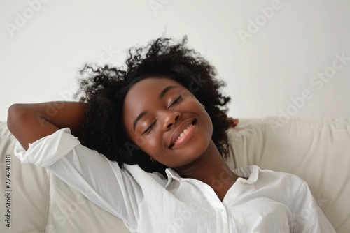 happy young african american woman relaxing and lying on the sofa at home white background