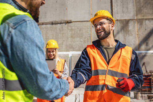 Contractor. construction worker team hands shaking after plan project contract  at construction site, contractor, engineering, partnership, construction concept photo