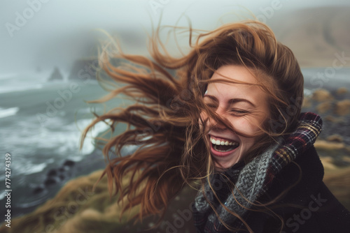 A woman laughing with her hair blowing in the wind