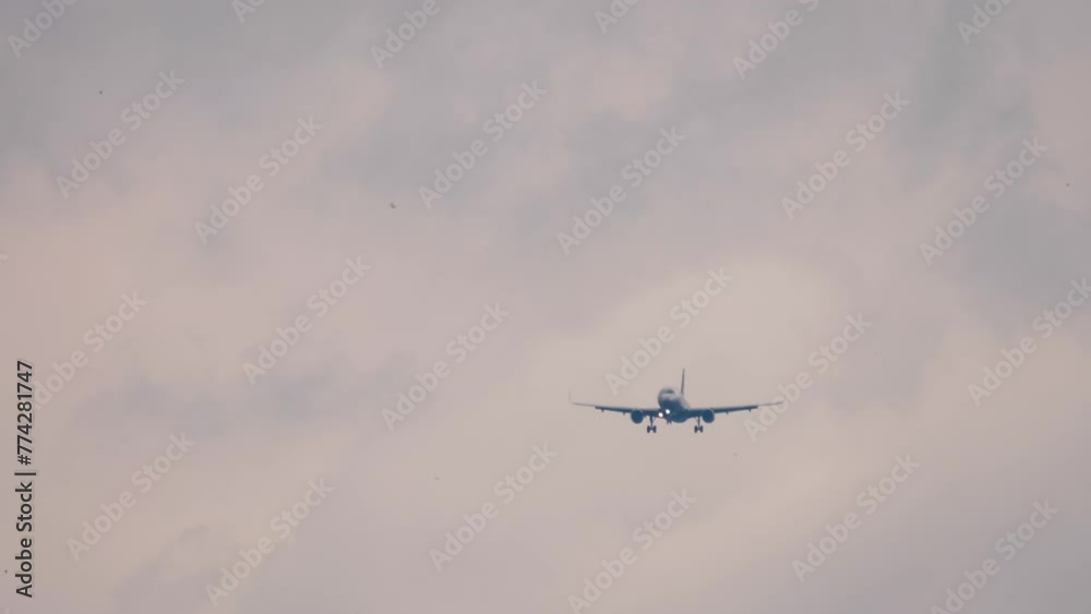 Airplane approaching for landing in the twilight sky, long shot, front view. Footage of a jet airliner flying. Travel concept Airplane approaching for landing in the twilight sky, long shot, front view. Footage of a jet airliner flying. Travel concept