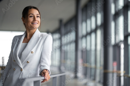 Wallpaper Mural Confident elegant woman in white jacket standing in the premises with big windows Torontodigital.ca