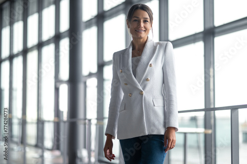 Woman in white jacket standing on the big window background