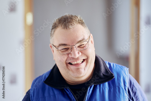 Face of Caucasian man in his 40s with mocking laugh and an insolent grin.
