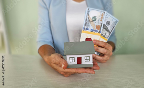 Young casual woman with money and house © Nadzeya