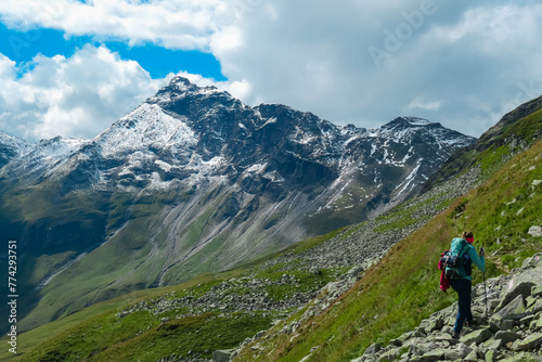 Hiker woman on extreme alpine terrain with scenic view of majestic mountain peak Vorder Geisslkopf, High Tauern National Park, Carinthia, Austria. Idyllic hiking trail remote Austrian Alps. Wanderlust
