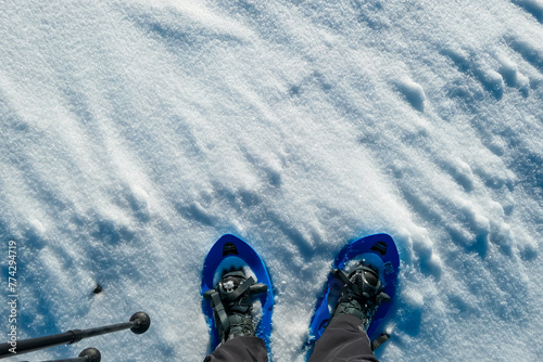 Close up view of person wearing snow shoes on snowy alpine meadow of Kor Alps, Lavanttal Alps, Carinthia Styria, Austria. Winter wonderland Austrian Alps. Sport activity for cold season. Snowshoeing photo