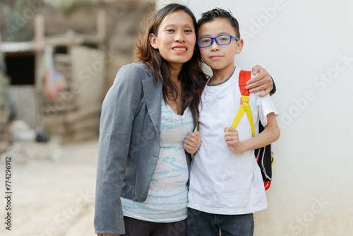 Portrait of mother and son ready to go to school. Hispanic mother and son outside school at back to school
