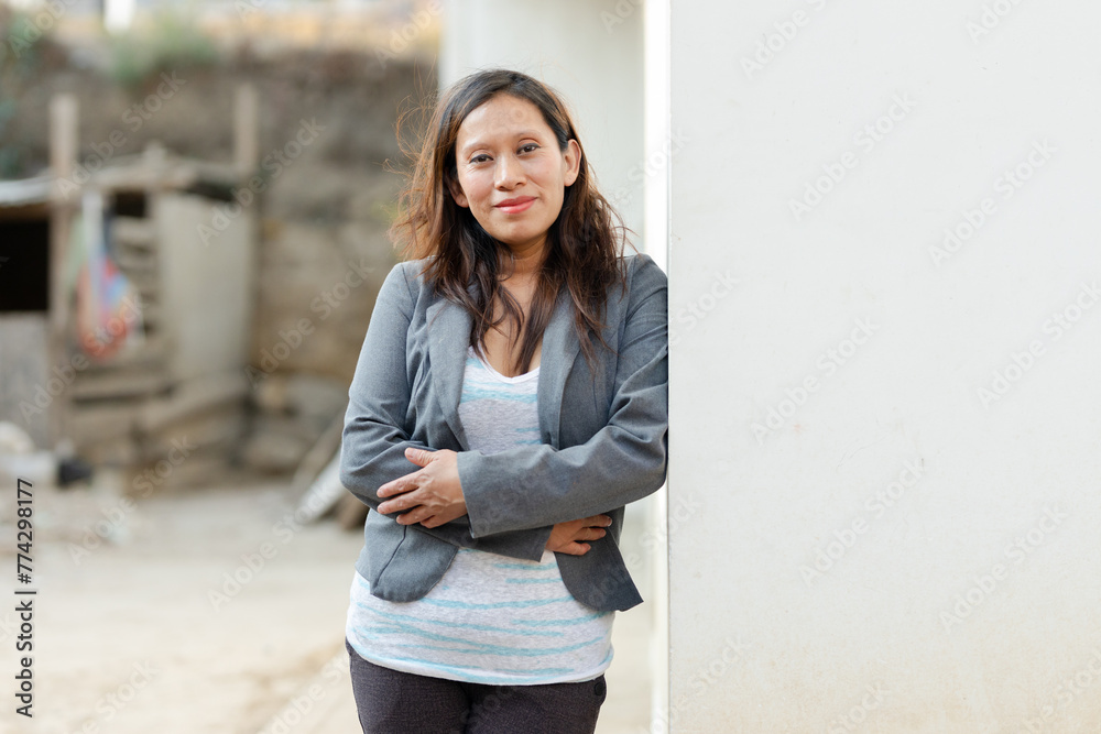 Portrait of Hispanic woman smiling outside her house in rural area - Happy Latin woman with arms crossed looking at camera - Mayan woman