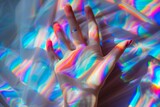 young woman's hand under rainbow prism lighting 