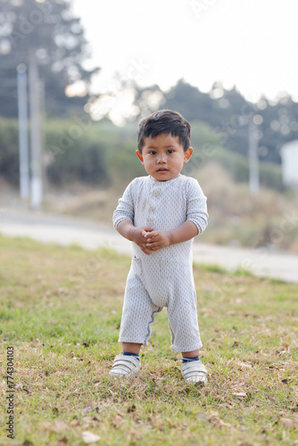 Hispanic toddler in the field .Little boy playing in the park. Latin boy taking his first steps
