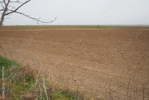 A tractor-plowed field in Chalma, Serbia. Agribusiness. Agricultural land. Fertile black soil. Row of furrows in a plowed field prepared for planting crops in the spring. Horizontal perspective view. photo