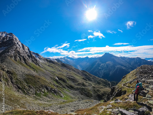 Hiker woman on alpine meadow with panoramic view of majestic mount Hochalmspitze in High Tauern National Park, Carinthia, Austria. Idyllic hiking trail in Austrian Alps. Wanderlust paradise Mallnitz photo