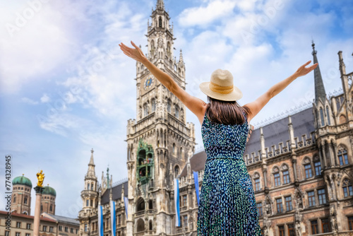 A tourist woman enjoys the beautiful view of the gothic building of the Old town Hall at Marienplatz Square, Munich, Germany 