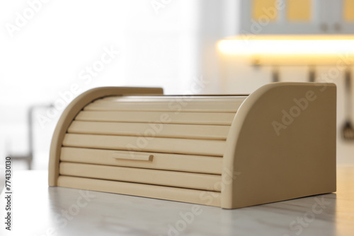 Wooden bread box on white table in kitchen, closeup