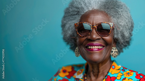 Cheerful elderly lady with colorful outfit and patterned sunglasses.
