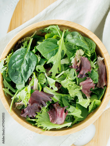 Fresh variety of salad greens in brown bowl
