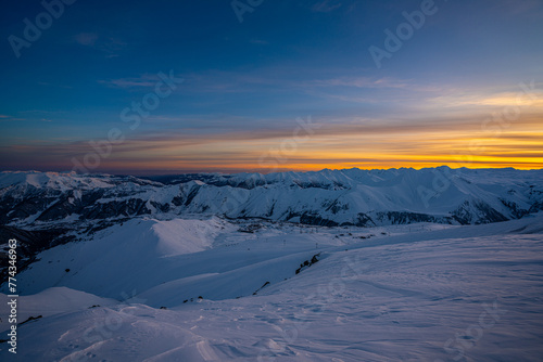 Sunset over snowy mountains © George Kurashvili