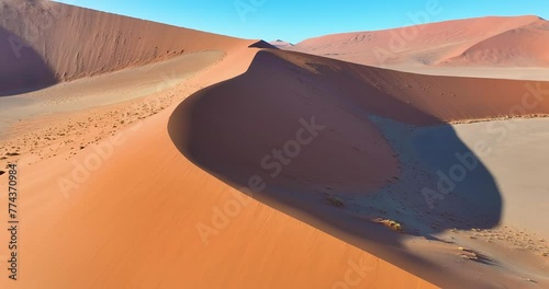 Drone flight over the glowing red sand dunes of the Namib Desert in Sossusvlei early in the morning