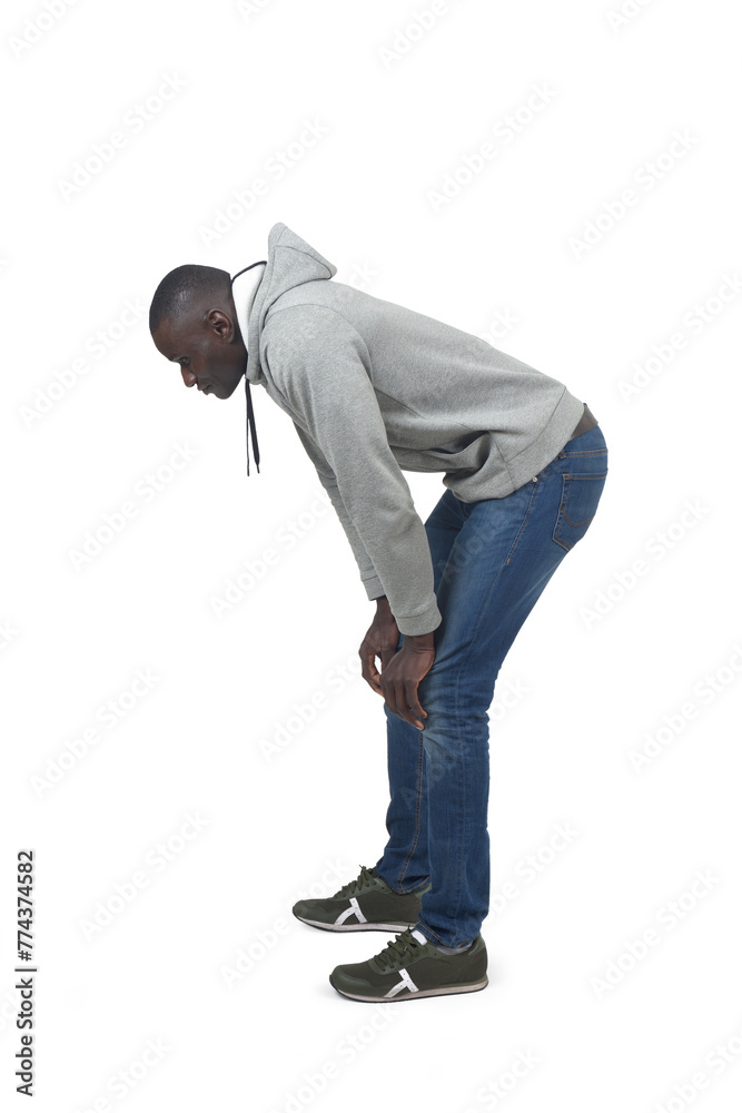 Naklejka premium Side view portrait of a crouching man looking down on white background.