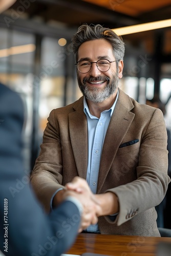 Glücklicher Geschäftsmann, Personalvermittler, HR-Manager, Hand schütteln beim Vorstellungsgespräch. Lächelnder, professioneller Führungsberater mittleren Alters und Bankkunde schütteln Hand photo