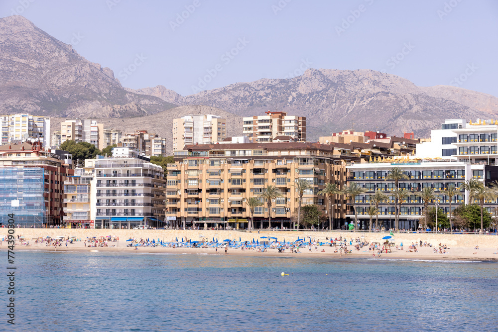 Photo of the town of Benidorm in Spain in the summer time showing the beach front and apartments on the beach front on the West Beach Promenade on a sunny summers day