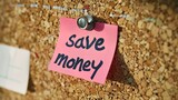 note pinned to a corkboard that says save money