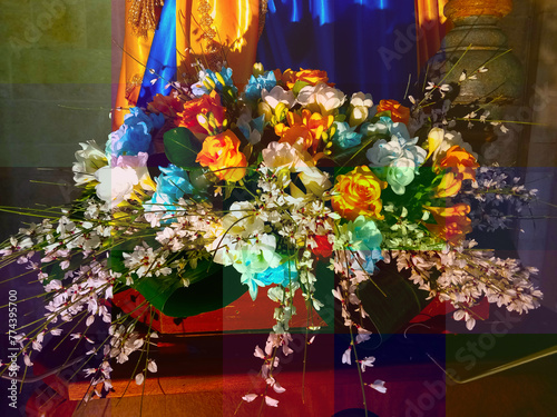 Addobbi floreali ai piedi della statua raffigurante la Madonna photo