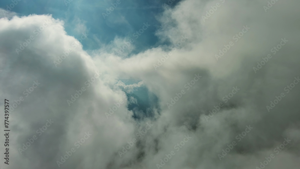 Flying through clouds between mountains Flying through clouds between mountains