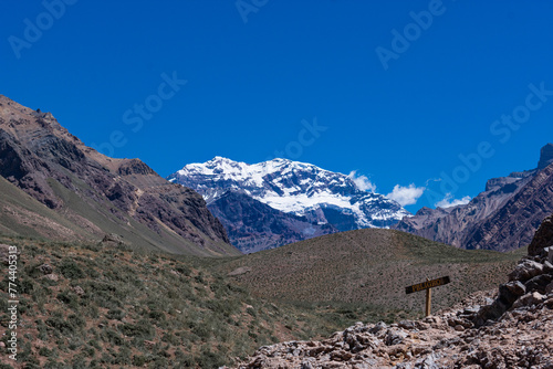 Mount Aconcagua dominating the valley, Mendoza, Argentina. Snow covered mountains in winter with a danger sign
