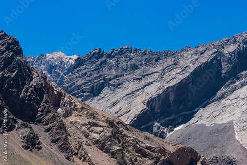 Mount Aconcagua dominating the valley, Mendoza, Argentina. Snow covered mountains in winter with a danger sign