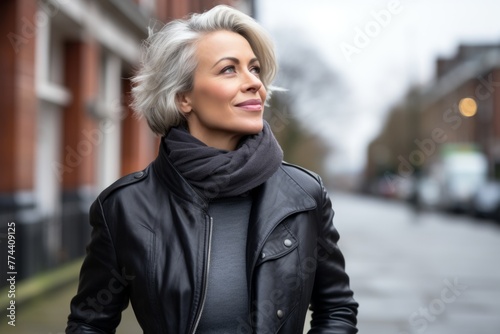 Portrait of a beautiful middle-aged woman in a black leather jacket on the street