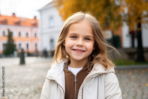 Portrait of a cute little girl in the city, autumn time