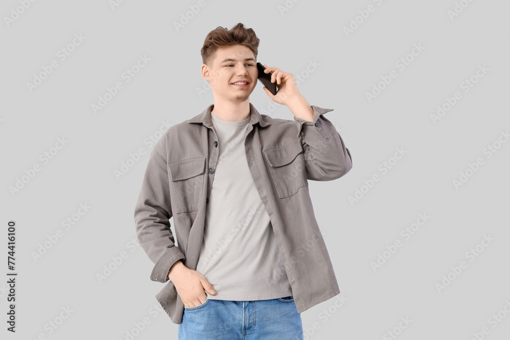 Young man talking by mobile phone on light background Young man talking by mobile phone on light background