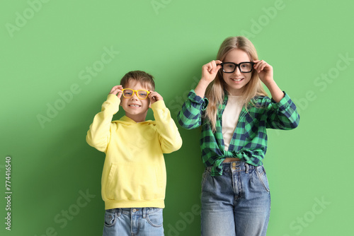 Cute little children in eyeglasses on green background © Pixel-Shot