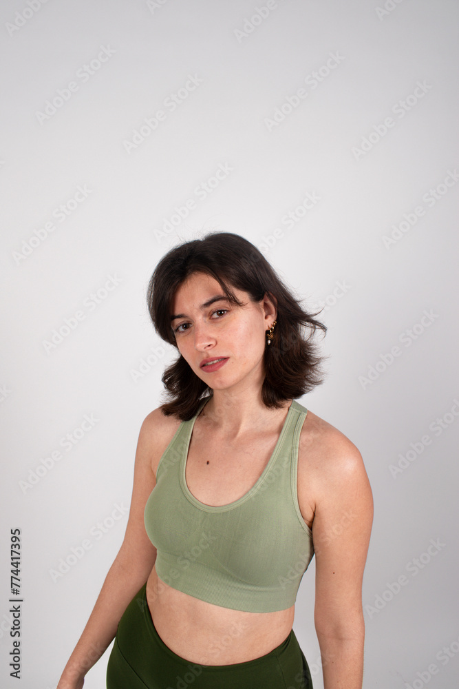 Portrait of a young woman in casual green top, posing with a confident look on a plain background. Portrait of a young woman in casual green top, posing with a confident look on a plain background.