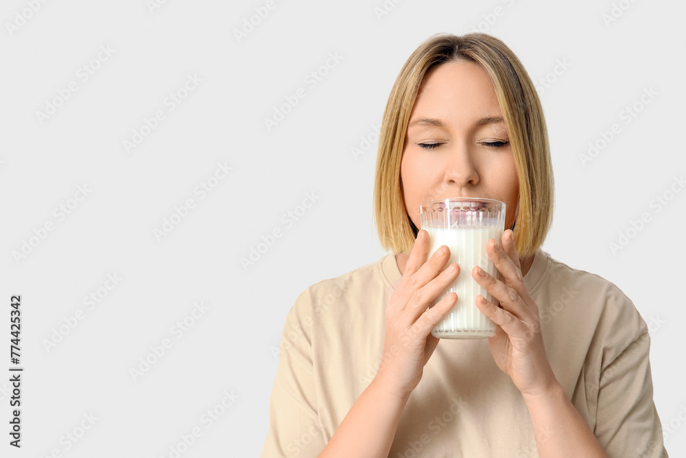 Beautiful young woman drinking fresh milk on white background Beautiful young woman drinking fresh milk on white background