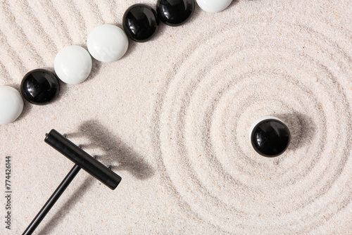 Photography Rake and stones on sand with lines in Japanese rock garden, top view