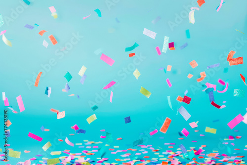 Colored confetti flying in the blue sky. Are small pieces or streamers of paper, mylar, or metallic material which are thrown at parades and celebrations. photo