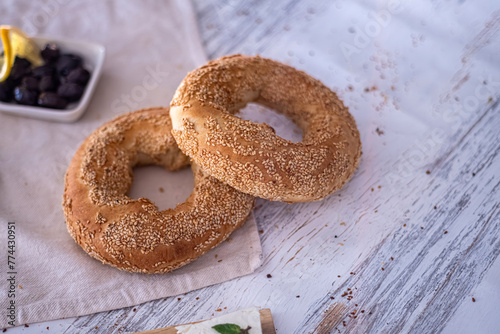 Photo of pastry food lifestyle. Sesame bagels baked in the oven on a white background. Turkish simit bread pretzels. Selective focus.