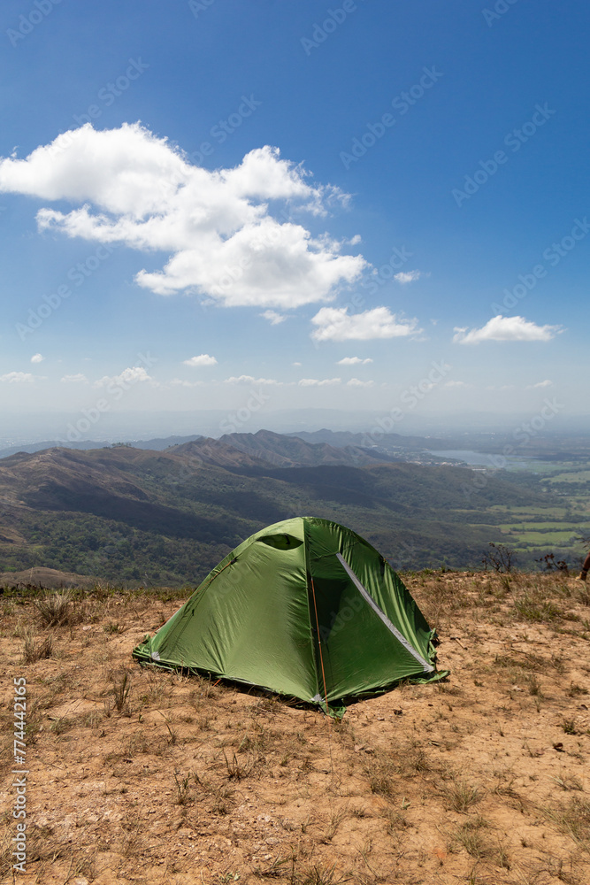 Green camping tent on top of mountain during dry season or summer. Enjoying time in the outdoors. Trekking concept.