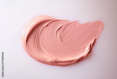 A swatch of cream blush is artfully spread on a neutral-toned background, highlighting the products creamy texture