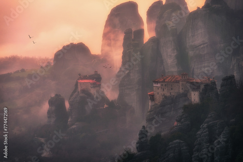 Beautiful misty moment in the rocks of Meteora in Greece at sunset surrounded with monasteries and flying birds.  photo